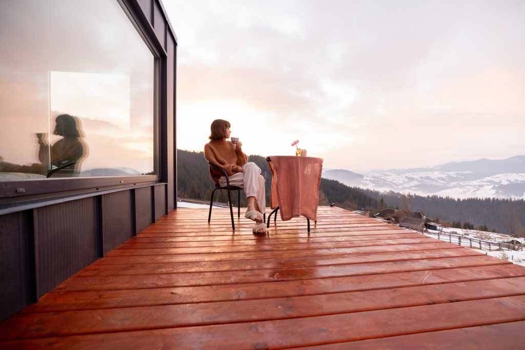 Woman resting at small house in the mountains