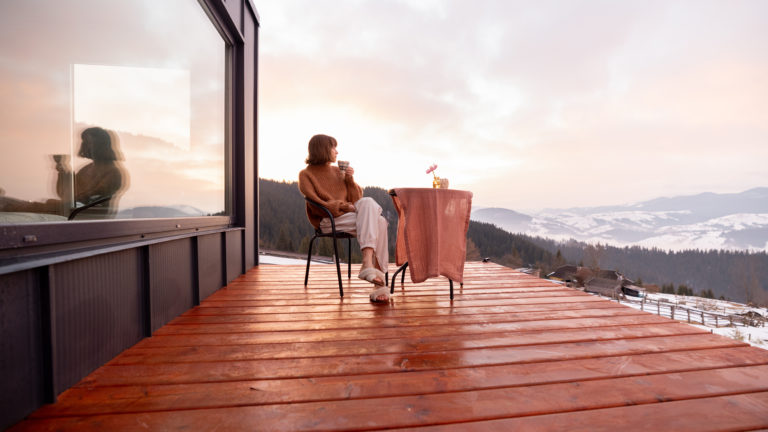 Woman resting at small house in the mountains